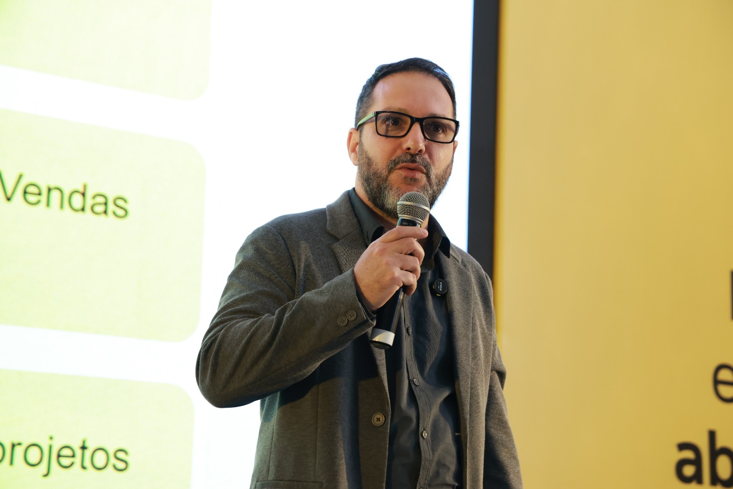Ricardo Veríssimo durante uma palestra, com microfone em mãos
