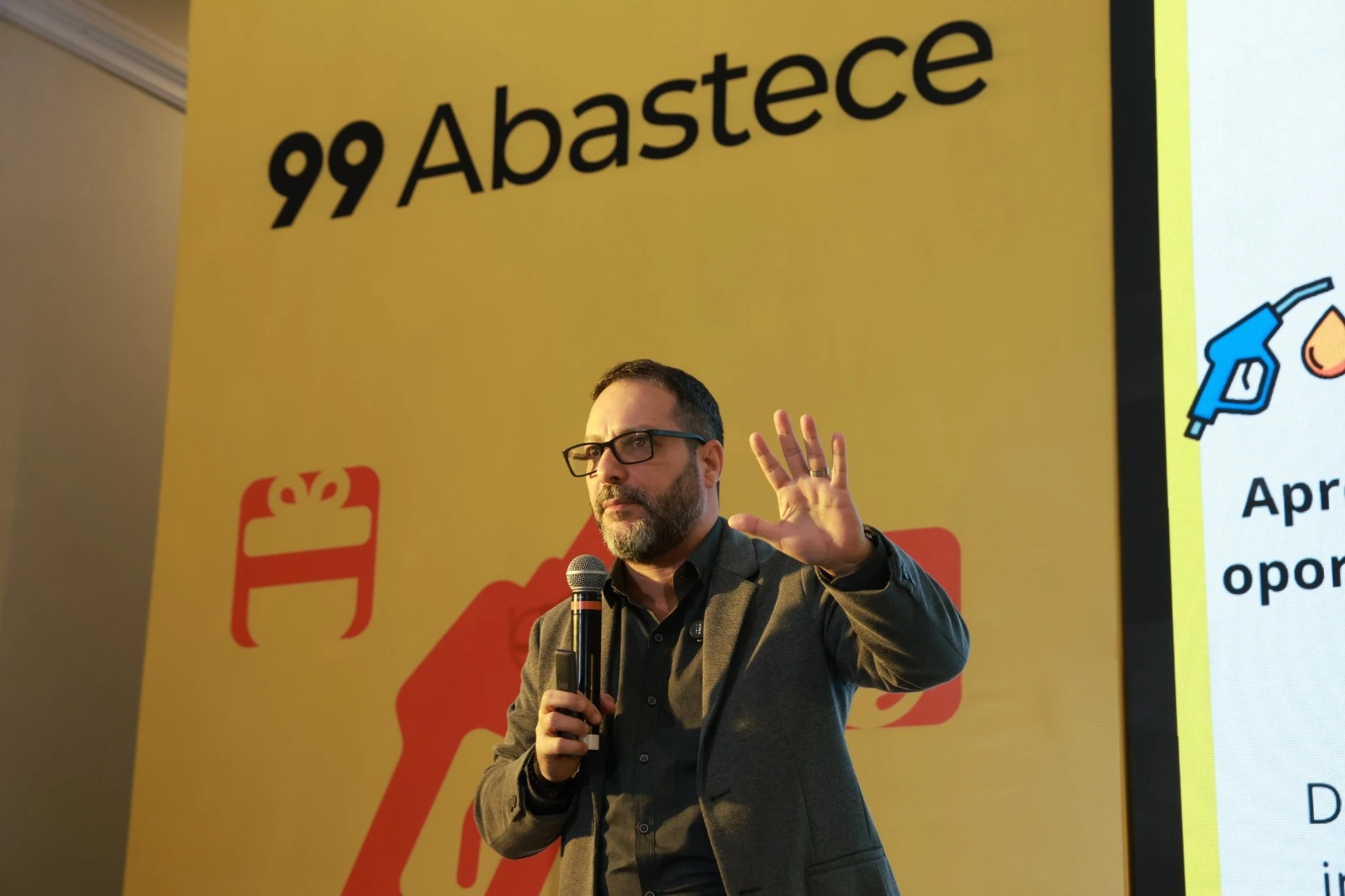 Ricardo Veríssimo fala diante do painel da 99Abastece